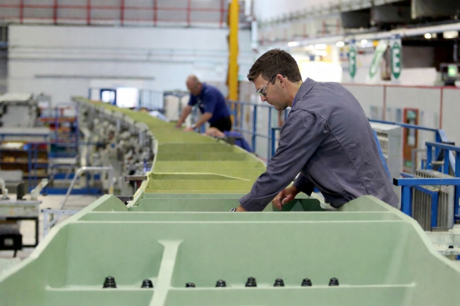 Engineer inspecting aircraft wing structure on the assembly line