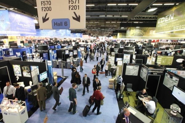 Aerospace trade show exhibition hall with visitors and exhibitor stands