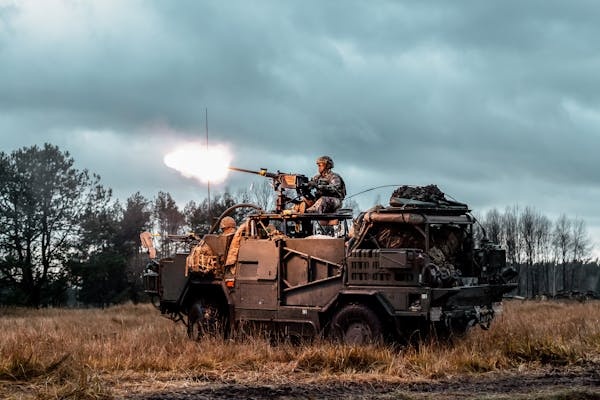 Military armoured vehicle with mounted weapon firing