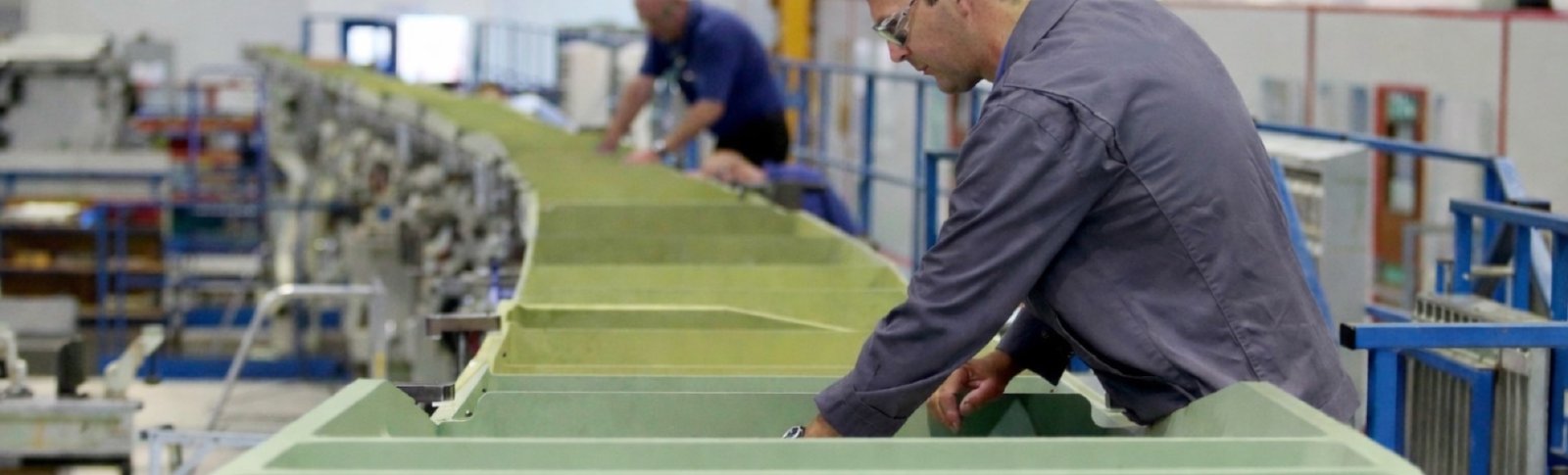 Engineer inspecting aircraft wing structure on the assembly line