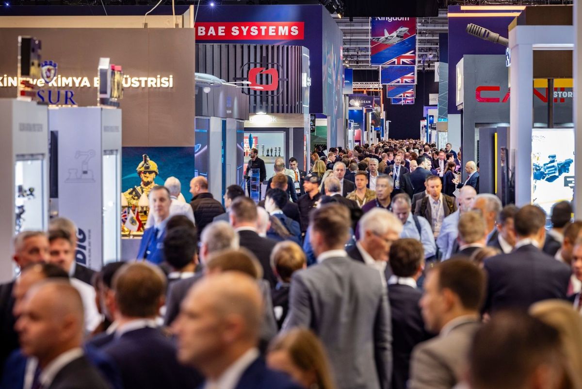 Defence trade show exhibition floor with exhibitors and visitors